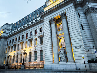 Naklejka premium Grand neoclassical city 10 Trinity Square building with columns and statue in London, UK at dusk on a quiet street. Four Seasons Hotel London at Ten Trinity Square.