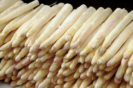 Fresh white asparagus stacked at market