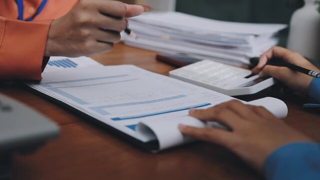 Two business people talk project strategy at office meeting room. Businessman discuss project planning with colleague at modern workplace while having conversation and advice on financial data report.