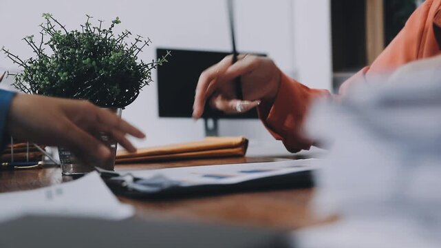 Two business people talk project strategy at office meeting room. Businessman discuss project planning with colleague at modern workplace while having conversation and advice on financial data report.
