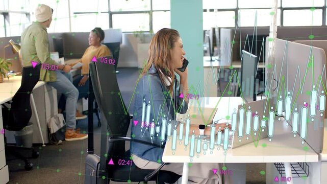 Seated woman taking call and typing, causing animated finance charts while colleagues shaking hands