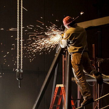 Welder at work with sparks in industrial setting
