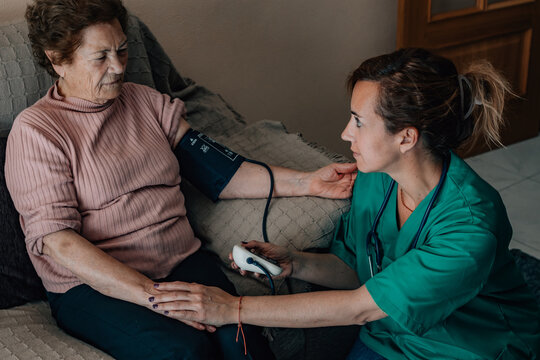 Home Healthcare -A healthcare professional measures an elderly woman's blood pressure at home, capturing the warmth, trust, and dignity of personalized in-home medical care