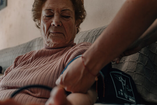 Home Healthcare -Elderly woman receiving home hospitalization care, including vital signs and blood pressure checks.