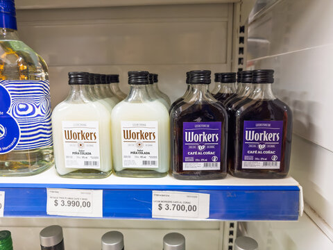 Argentina, El Chalten, March 05, 2026, Workers, glass bottle, 0,2 l, bottles of Pi&ntilde;a Colada and Caf&eacute; al Co&ntilde;ac liqueurs on a supermarket shelf