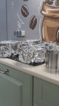 Three golden sponge cakes baking in metal rings lined with foil Description,Three round sponge cakes with golden-brown tops bake inside metal springform rings. The sides of the rings are lined with cr