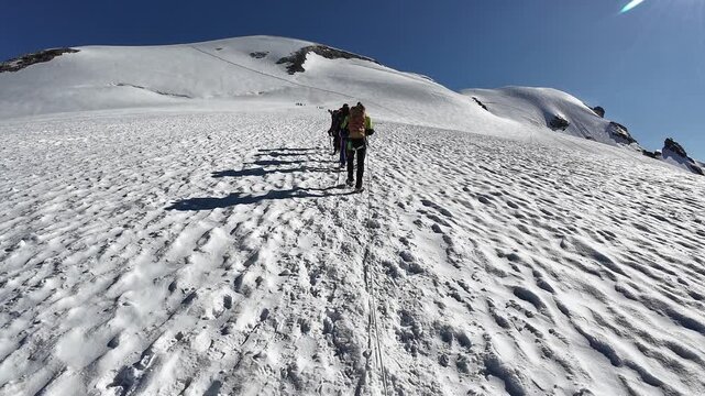 POV mountaineering in rope team with mountaineer and mountain glacier panorama towards summit Breithorn in Swiss Alps, canton of Valais, Switzerland