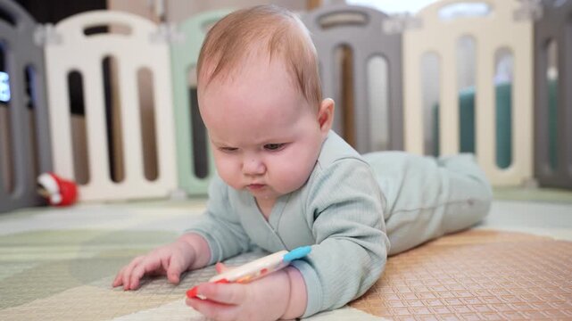 Cute 7 month old baby girl playing and making fun while tummy time. 