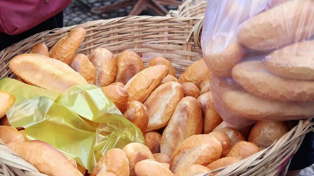 Vietnam street market, man buying mini baguettes from basket. Authentic Southeast Asia food culture, fresh bakery trade, local lifestyle and daily commerce concept.
