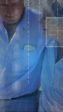 Vertical video: Seniors sitting camera pulling back causing binary over couple pocket item talking