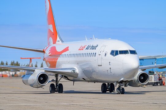 Radisson, Quebec, 2022-04-28, A white and orange Boeing 737 airplane on the tarmac at La Grande Airport under a blue sky