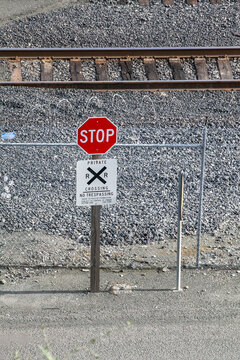 Railroad crossing stop sign at active rail line with safety markings
