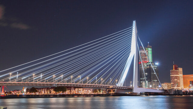 The iconic Erasmus Bridge, Maastoren Rotterdam and  Wilhelminatoren illuminated at night on Kop van Zuid - a beautiful Dutch landmark
