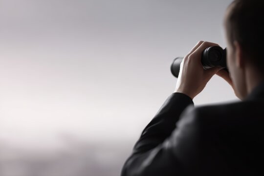 Businessman with binoculars looking forward, vision concept