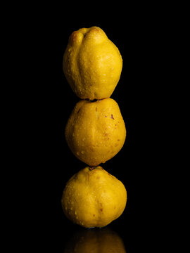 three quinces on black background