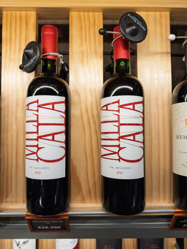 Santiago, Chile, March 09, 2026, Vik Milla Cala, glass bottle, 0,75 l, red wine bottles on a wooden shelf in a retail store with Pernod Ricard security tags.
