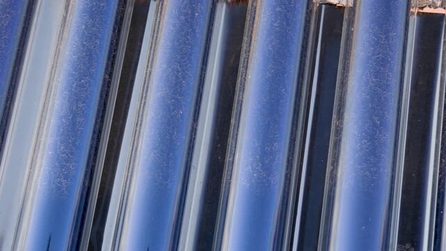 Close-up of blue metal roofing sheets with repeating lines and reflections. Industrial construction material texture background.
