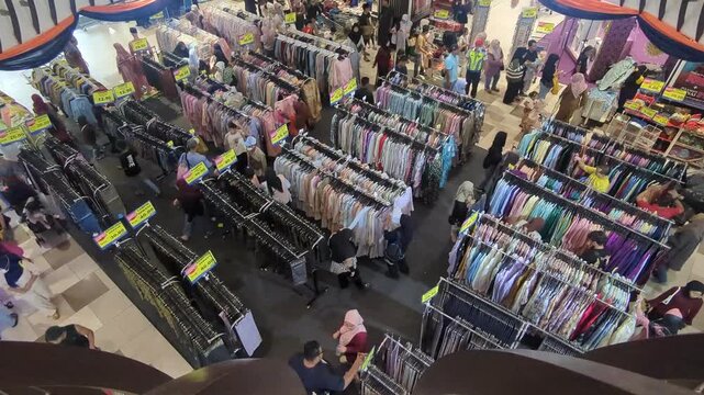 Time-lapse of busy customers browsing and shopping at a crowded clothing department store in a shopping mall during public holiday.