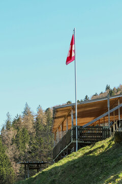 Swiss flag at the rural village with many traditional houses in autumn.