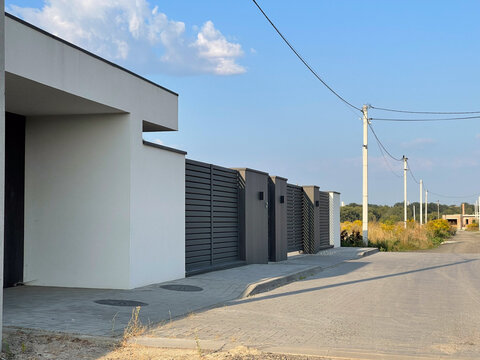 New Housing Development Along a Quiet Street With Electricity Poles and Clear Skies in the Background