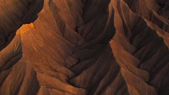 Top down aerial view slowly flying over intricate patterns of an eroded, dry, and rocky landscape