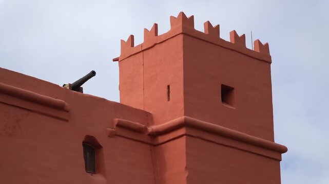 Historic artillery cannon on Saint Agatha's Tower red stone walls in Malta.