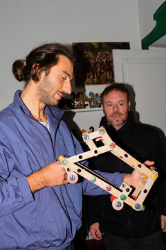 Engaging Discussion on Wooden Model in a Cozy Indoor Setting