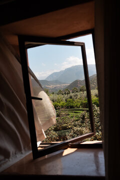 The view of the Atlas Mountains through an open window of a hotel 