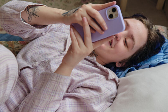 Checking smartphone looking happy and relaxed online