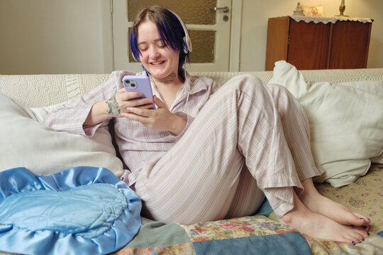 Young adult having fun checking their phone relaxing at home