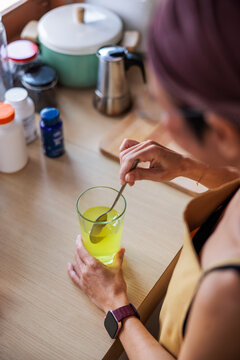 Woman stirs powder supplement into water