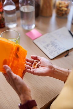 Person takies the day's vitamins from pill organizer