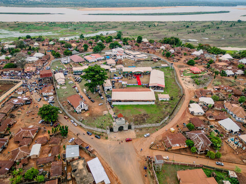 Aerial view of the Attah of Igala Palace compound with a red carpet and gathered people near the Niger River in Idah, Kogi, Nigeria.