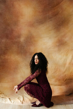 Woman with curly hair crouching 