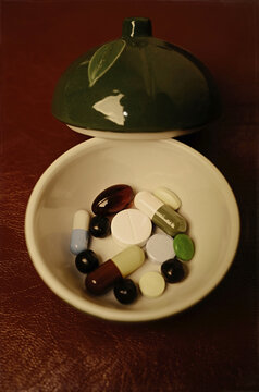 Different types of pills are placed in a small dish
