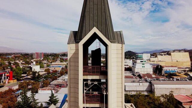 Aerial close-up view of a church bell tower with city landscape in the background, 4K San Bernardo, Chile