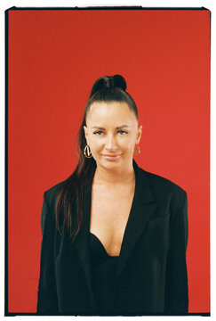 Woman in Black Blazer Against Solid Red Background