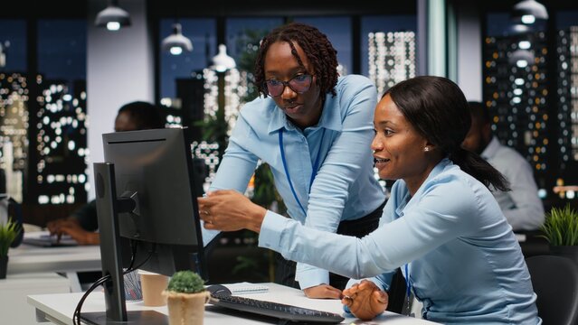 African american workers group analyzing performance metrics at desktop with high tech, aligning business strategy and objectives to drive results within a multinational company.