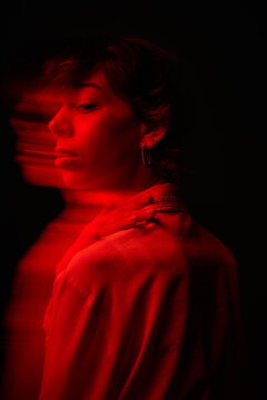 Portrait of a woman with red lighting in a dark space