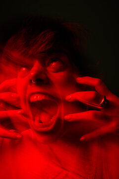 Person shows strong emotion in red light setting at night