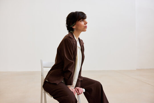 Woman sitting on chair in a spacious indoor setting