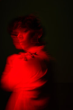 Person with blurred motion effect in red lighting at night