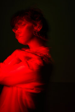 Woman standing in red light with motion blur effect