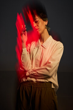 Woman smoking in a dark room with red light effects