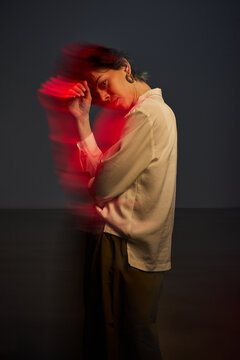 Woman with red light moving in dark setting