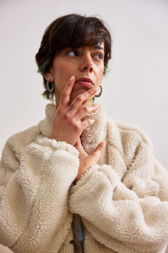 Woman thinking while posing in a cozy jacket indoors