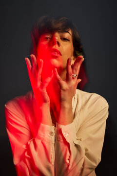 Woman posing with red light in dim setting during indoor shoot