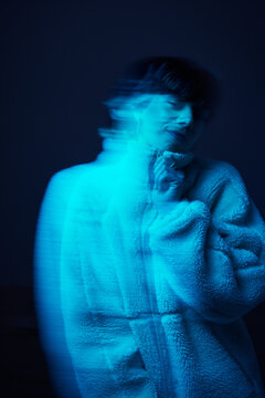Person wearing a fluffy garment in blue light at night