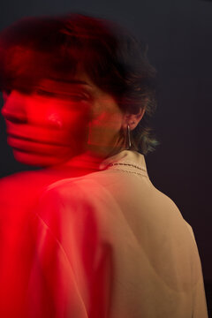 Person with blurred motion in red light at an indoor location