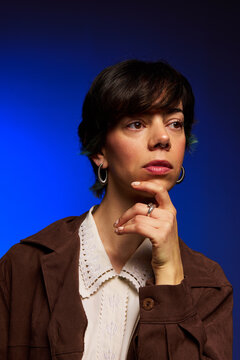 Thinking woman with a thoughtful expression in a blue setting